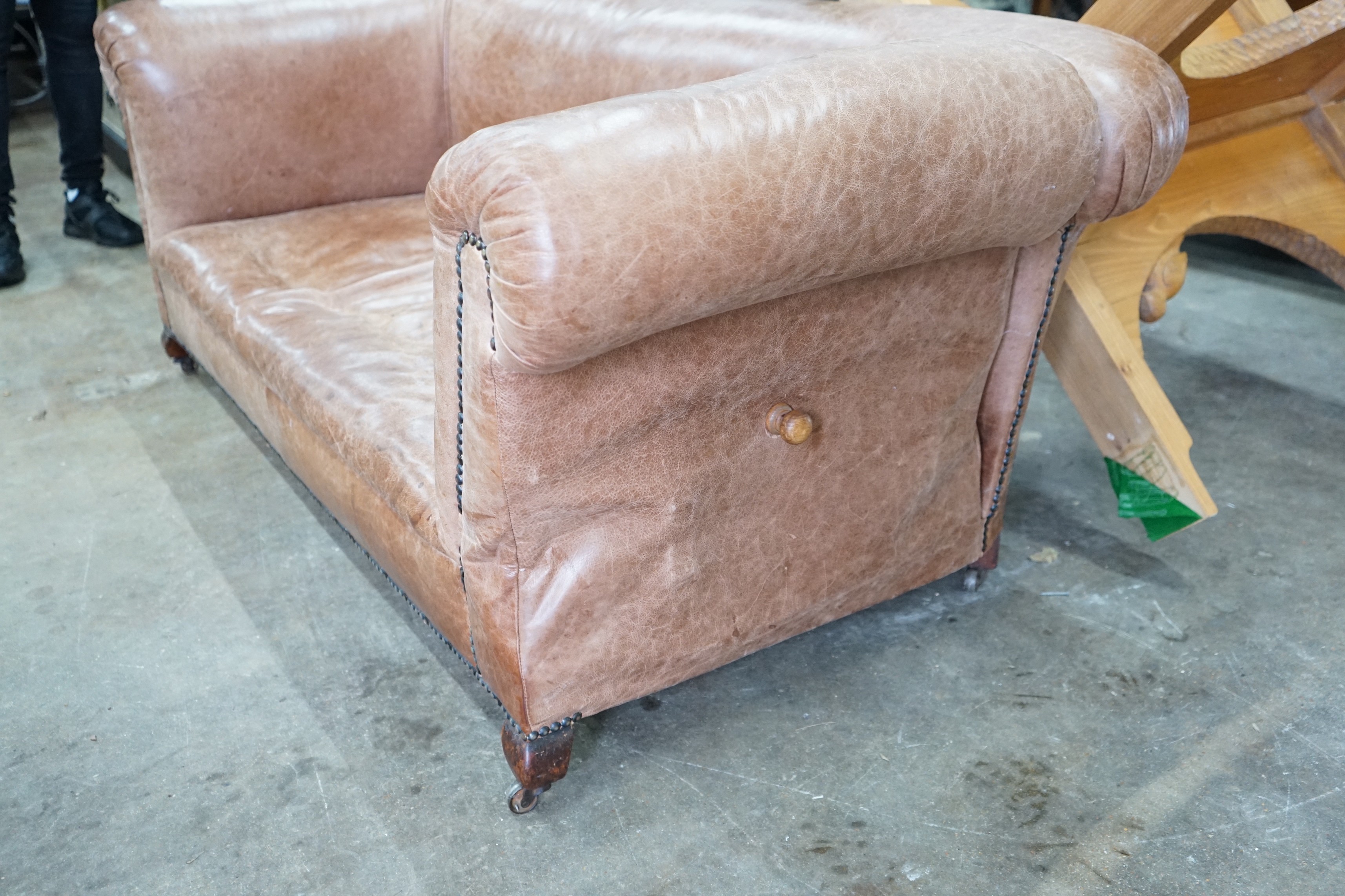 An early 20th century tan leather drop arm Chesterfield settee, width 160cms, depth 84cms, height 69cms.